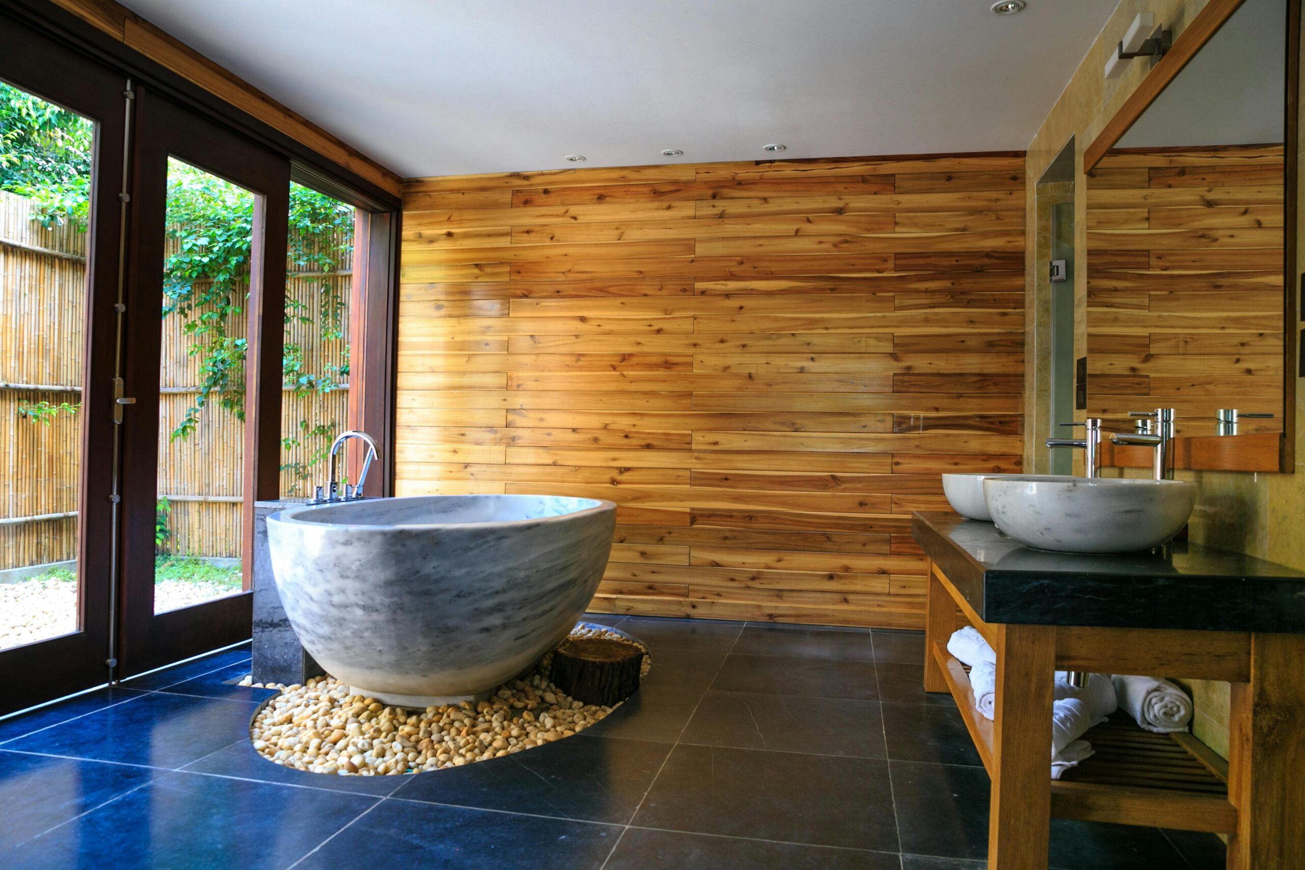 Elegant bathroom showcasing a modern marble tub and wooden interior for a serene escape.