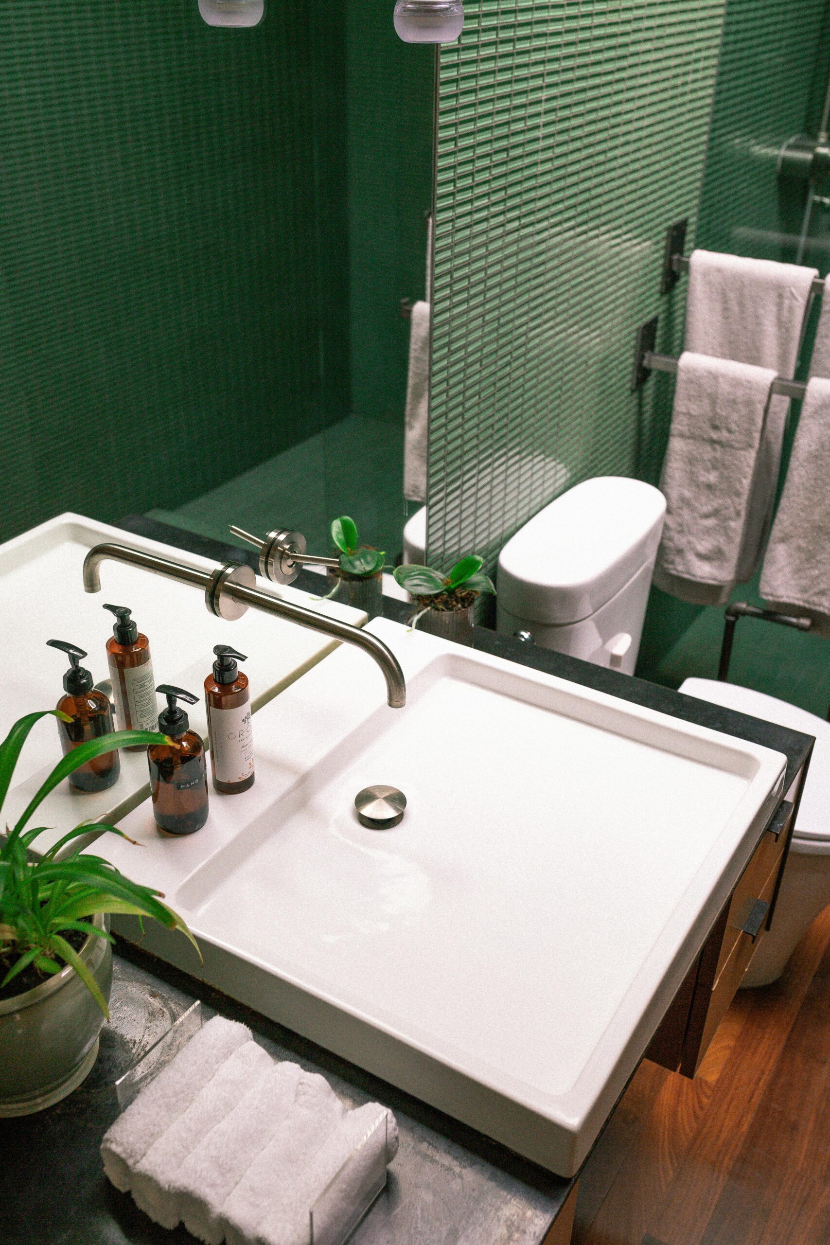 Elegant green bathroom features modern sink and stylish fixtures.